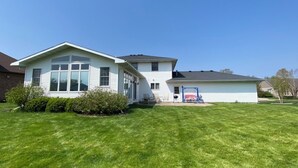 Une maison de plain-pied avec une grande pelouse devant et un garage.