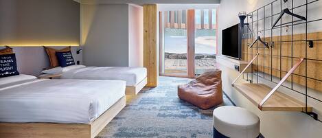 A modern hotel room with two beds, a large window, a TV, and a wall-mounted rack.