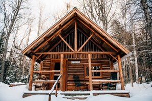 A log cabin with a porch, a sign reading "GRAY GHOST," and a chair outside. - Trout Fishing Cabin, Canoes Included, Shared Bath & Sauna (Greenville)