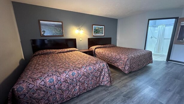 A room with two beds, a flat-screen TV, and a large window. - Fairway Inn Florence (Florence)
