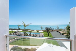 Vista de un resort con piscina, sillas de descanso y una playa.