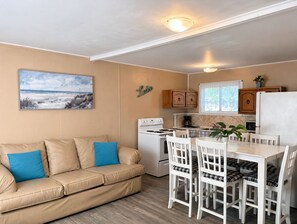 Pieni keittiönurkkaus, jossa on liesi, mikroaaltouuni ja jääkaappi.