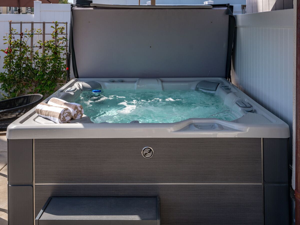 A hot tub with a built-in seat and a towel on top.