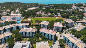 A residential area with apartment buildings, a sports field, and a view of the sea. - Apartment Santa Monica (Albufeira)
