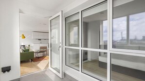 Un apartamento moderno con cocina, zona de comedor y grandes ventanales con vistas a la ciudad.