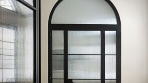 A room with a round table, four chairs, a glass door, and a tiled floor. - La Corte dei Panni (Rome)