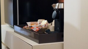 A kitchenette with a coffee maker, a basket of snacks, and a refrigerator. - La Corte dei Panni (Rome)