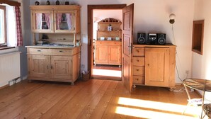 A wooden-paneled room with a cabinet, a small table, and a chair. - Landhaus - Nahe Starnberger See (Eberfing)