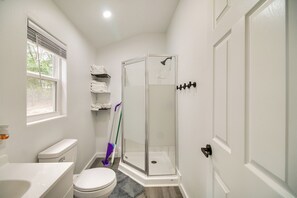Un baño con inodoro, lavamanos, ducha y ventana.