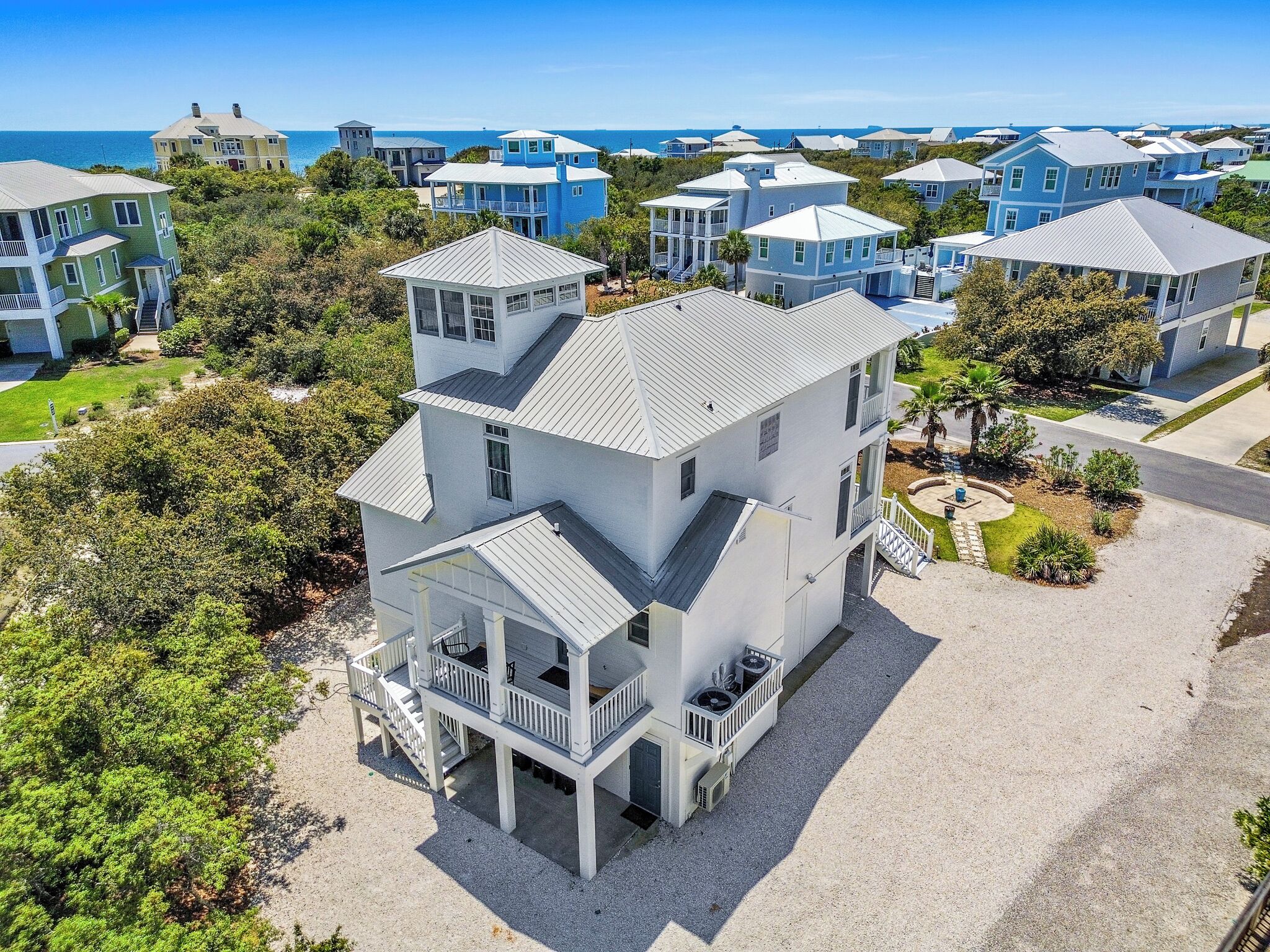A coastal residential area with multiple two-story houses featuring balconies and a central house with a prominent tower.