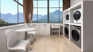 Una cocina moderna con un ventanal grande, un lavabo y dos lavadoras.