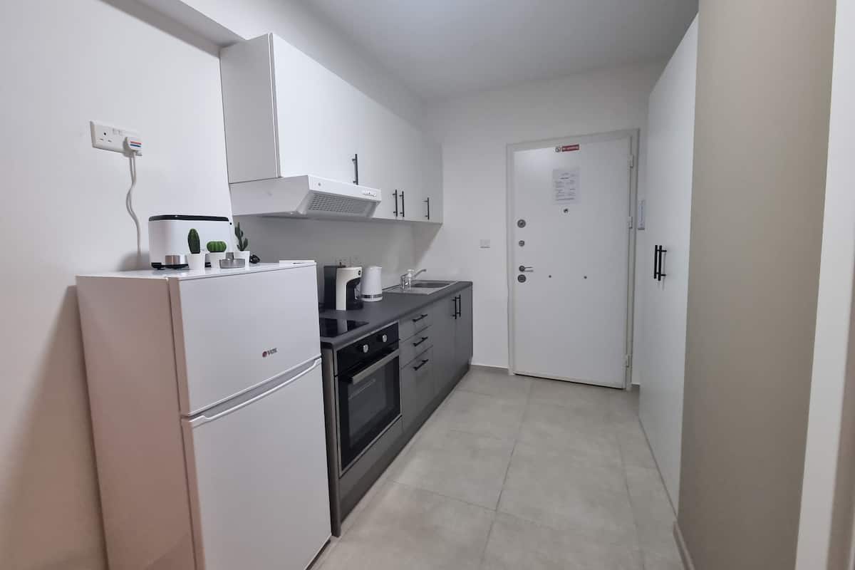 Habitación triple básica, vista al patio | Cocina privada | Refrigerador con congelador, microondas, horno y parrilla de estufa