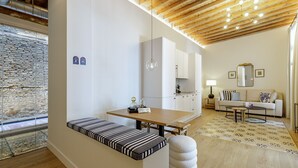 Ein modernes Wohnzimmer mit einer Couch, einem Esstisch und einer Küchenzeile.