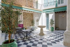 A café with outdoor seating, a stone wall, and a checkered floor.