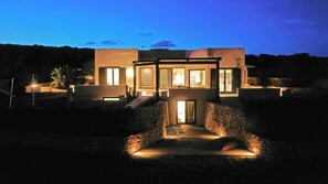 A modern house with a central courtyard, large windows, and a stone pathway leading to the entrance. - Villa Fronte Mare Stornello 2 - ... (Favignana)