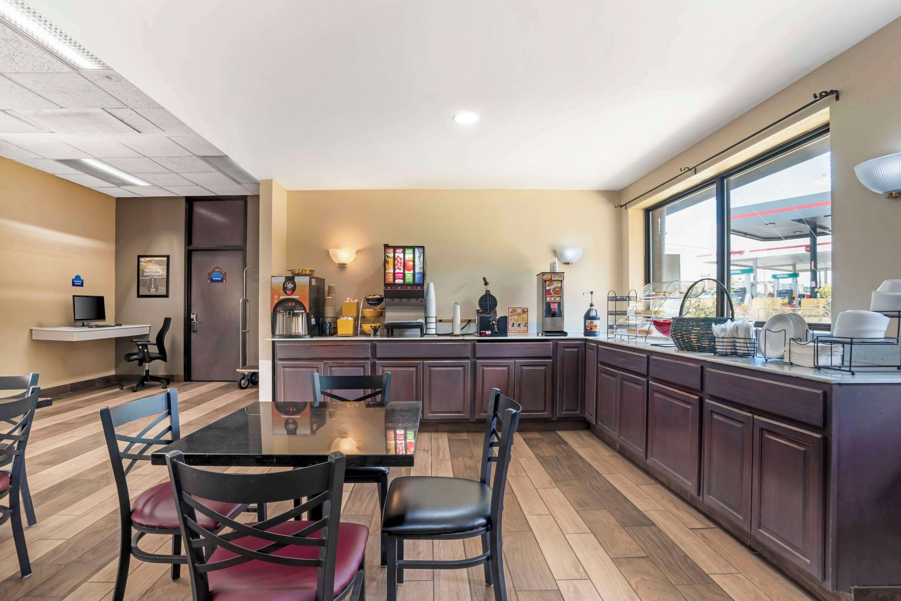 Una cocina moderna con una isla central, armarios de madera oscura y un amplio ventanal con vistas al exterior.