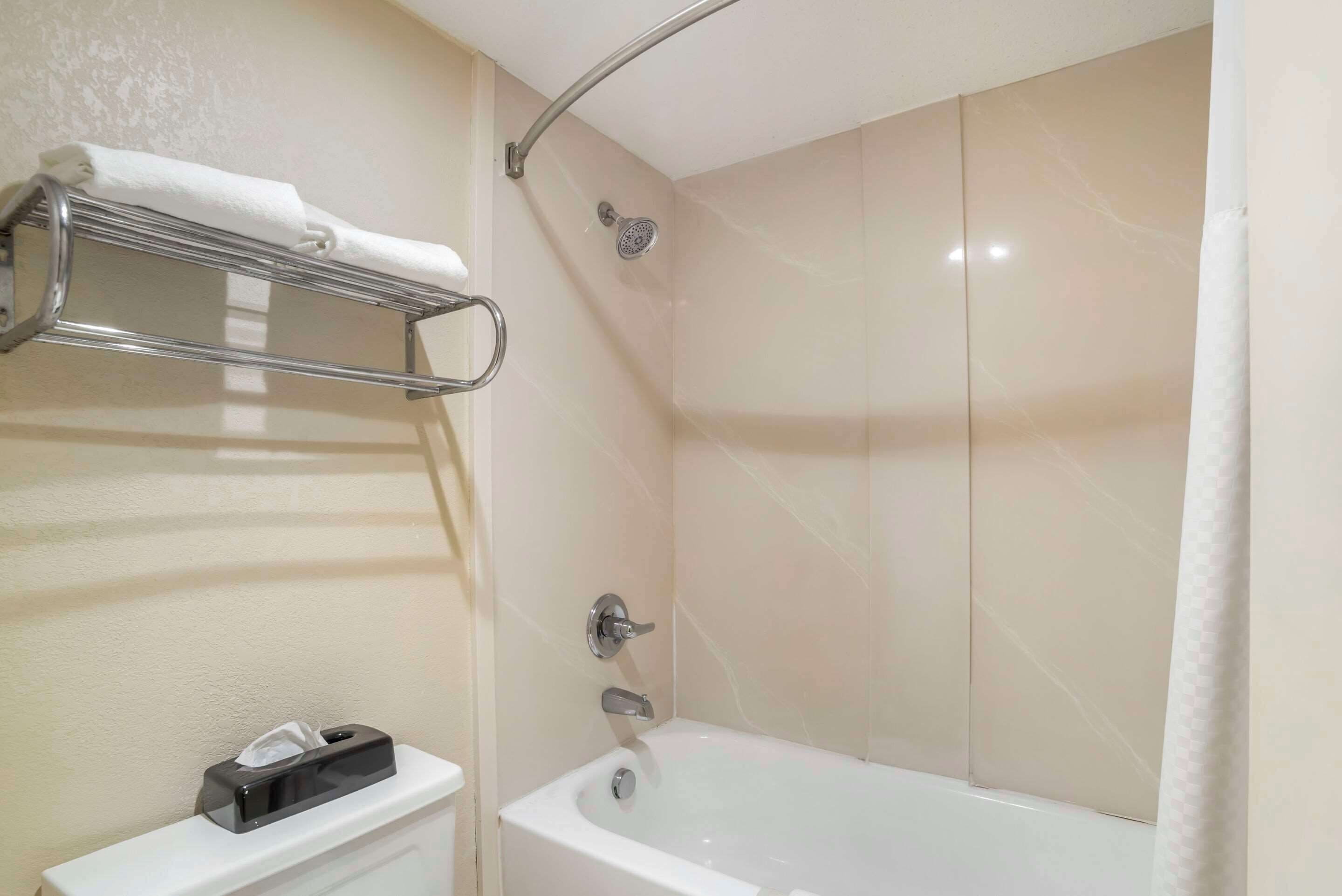 A bathroom with a bathtub, a towel rack, and a toilet.