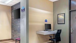 Un espace d’accueil comprenant un bureau, un ordinateur et une chaise.