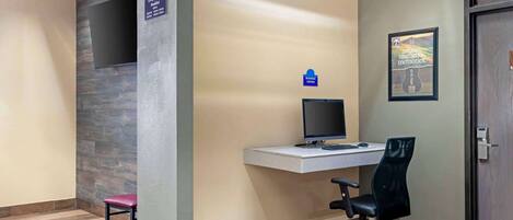Un área de recepción con escritorio, computadora y una silla.