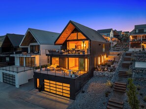 A modern two-story house with a large balcony, a garage, and a stone pathway leading up to the entrance. - Scandinavi Inn  (Chelan)