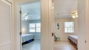 A bedroom with two beds, a ceiling fan, and a window with blinds. - Walk to Pier: St Augustine Beach Condo w/ Balcony! (St. Augustine Beach)