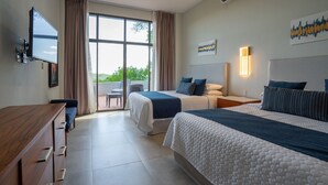 Une chambre d’hôtel avec deux lits, une télévision, un bureau et un balcon avec vue.