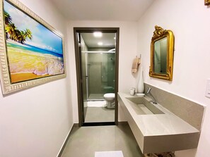 Ein Badezimmer mit Glasduschtür, Waschbecken und Spiegel.