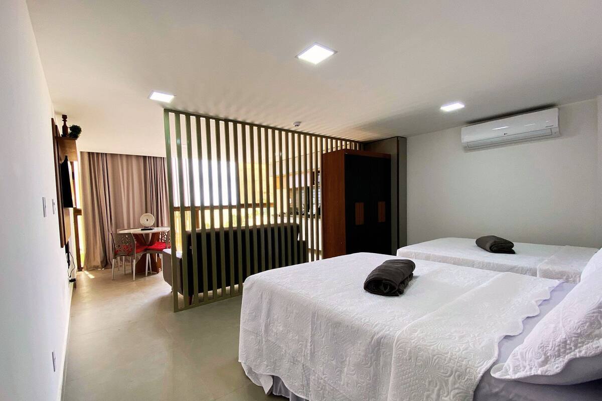 A hotel room with two beds, a desk, and a chair.
