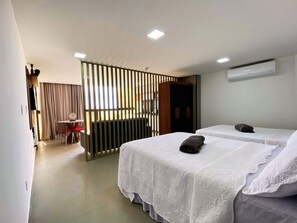 Ein Hotelzimmer mit zwei Betten, einem Schreibtisch und einem Stuhl.