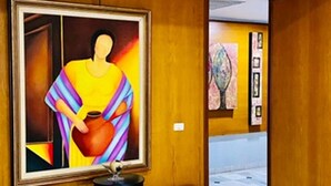 A hallway with wooden paneling, a large framed painting, and a small table with a chair. - Intercity Tower Hotels  (San Pedro Sula)