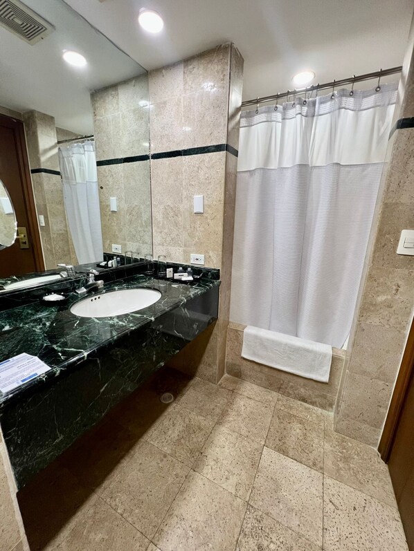 A bathroom with a marble sink, a mirror, a shower curtain, and a towel rack. - Intercity Tower Hotels (San Pedro Sula)