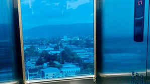 An elevator with a view of a cityscape through a large window. - Intercity Tower Hotels  (San Pedro Sula)