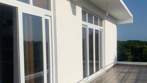Ein modernes Gebäude mit großen Schiebeg lass und einer Dachterrasse mit Fliesenboden.