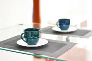 Guests can enjoy a minimalist retreat with a glass table and comfortable seating.