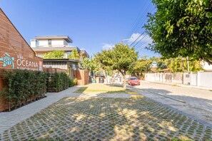 A paved pathway leading to a building with a sign reading 'Vila Oceana Unidade de Lagoa.' - *A/C*1000Mbps*Full Kitchen*Parking* (Florianópolis)