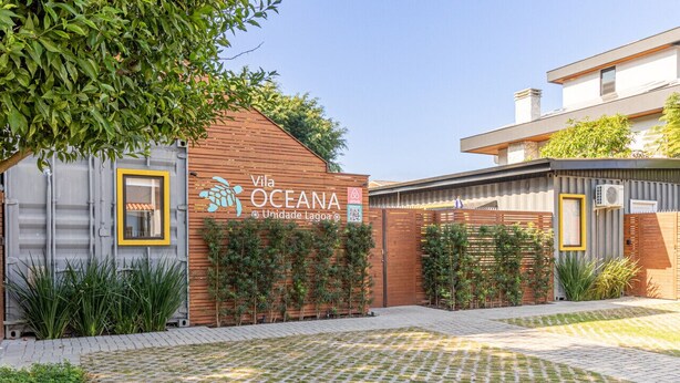 A modern building with a sign reading "Vila Oceana Unidade Lagoa". - *Self Check-In*A/C*Full Kitchen*10min->Beach* (Florianópolis)