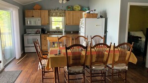 A kitchen with wooden cabinets, a stove, a microwave, and a refrigerator. There is a dining table with chairs and a ceiling fan above. - Lakefront spectacular view 

























 (Henrico)