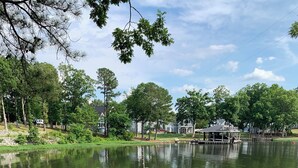 A wooden dock extending into a calm lake, surrounded by lush greenery and residential houses. - Lakefront spectacular view 

























 (Henrico)
