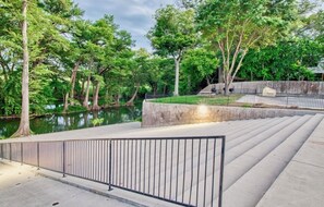 Stroll along the tranquil water's edge, surrounded by lush greenery and a serene atmosphere.