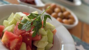 Ensalada de tomates, pepinos y perejil en un plato.