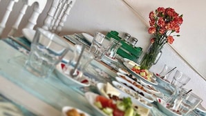 Una mesa lista para una comida con diferentes platos y vasos.