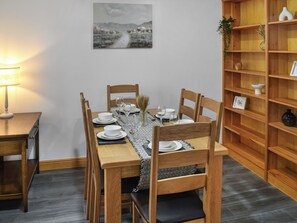 A dining area with a wooden table set for four, chairs, a lamp, and a bookshelf with decorative items. - New House Farm - UKC6912 (Cowan Bridge, near Kirkby Lonsdale)