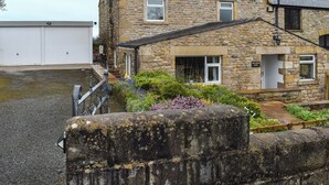 A stone house with a white garage, a garden with flowers, and a sign reading 'New House Farm'. - New House Farm - UKC6912 (Cowan Bridge, near Kirkby Lonsdale)