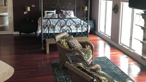 A spacious bedroom with a four-poster bed, a wicker chair, a ceiling fan, and large windows. - Royal View your holiday escape on Table Rock Lake near Branson Attractions. (Lampe)