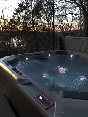 A hot tub with a control panel and a smartphone on the edge.