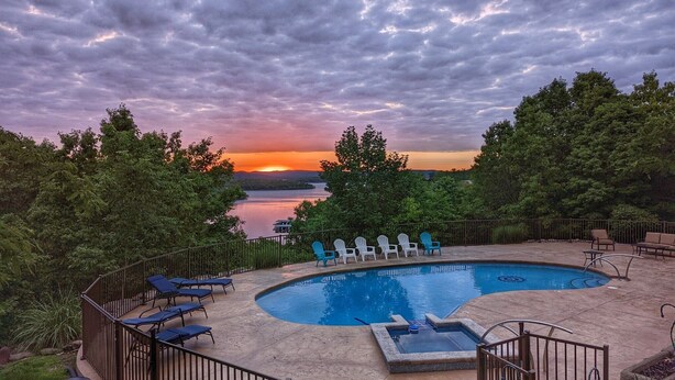 A swimming pool with lounge chairs and a view of a sunset over a lake. - Royal View your holiday escape on Table Rock Lake near Branson Attractions. (Lampe)