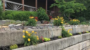 A garden with flower beds and a wooden fence. - Royal View your holiday escape on Table Rock Lake near Branson Attractions. (Lampe)