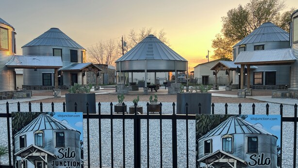 Il s’agit d’un ensemble de bâtiments rustiques comprenant plusieurs structures, dont un pavillon central et plusieurs bâtiments plus petits. On peut y voir des panneaux publicitaires pour « Silo Junction Lofts » ainsi qu’une adresse de site web, silojunction.com.