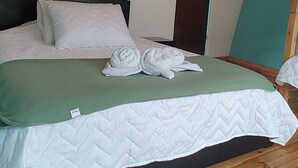 A wooden ceiling, a bed with a green blanket, and a white quilted bedspread. - LA TATA CABAÑA  ZON DE CAMPING  (Cucunubá)
