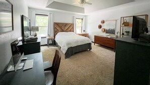 Un dormitorio con cama, escritorio, silla y ventilador de techo.